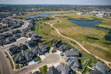 Saskatoon 'daki Rosewood mahallesinin yükseltilmiş görüntüsü, Saskatchewans' ın sakin doğal tuvaliyle iç içe geçmiş kentsel tasarım bir duvar halısı sunuyor..