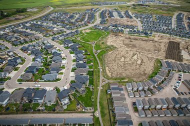 Saskatoon 'daki Rosewood mahallesinin yükseltilmiş görüntüsü, Saskatchewans' ın sakin doğal tuvaliyle iç içe geçmiş kentsel tasarım bir duvar halısı sunuyor..