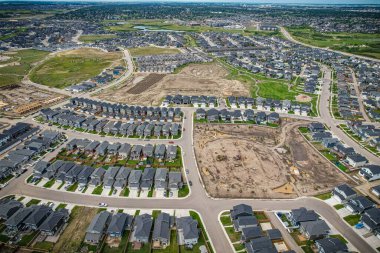 Saskatoon 'daki Rosewood mahallesinin yükseltilmiş görüntüsü, Saskatchewans' ın sakin doğal tuvaliyle iç içe geçmiş kentsel tasarım bir duvar halısı sunuyor..