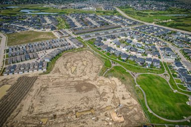 Saskatoon 'daki Rosewood mahallesinin yükseltilmiş görüntüsü, Saskatchewans' ın sakin doğal tuvaliyle iç içe geçmiş kentsel tasarım bir duvar halısı sunuyor..