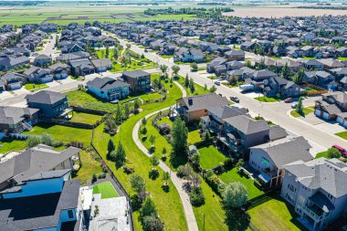 Saskatoon 'daki Willowgrove mahallesinin hava zarafeti, modern evlerin uyumlu etkileşimini ve Saskatchewan yeşilliğini sunar.