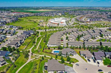 Saskatoon 'daki Willowgrove mahallesinin hava zarafeti, modern evlerin uyumlu etkileşimini ve Saskatchewan yeşilliğini sunar.