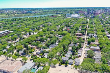 Saskatoon 'daki şehir parkına doğru bir bakış, kentsel yaşam ve park sükunetinin canlı bir karışımını vurguluyor, Saskatchewans' ın geniş ufkunun zeminine kuruluyor.