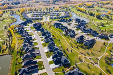 Saskatoon 'daki söğütlerin üzerinden uç, lüks yaşamın cazibesinin golf sahasının sakinliğiyle buluştuğu yere. Bu resim manikürlü manzaraları ve özel konutları yakalar..