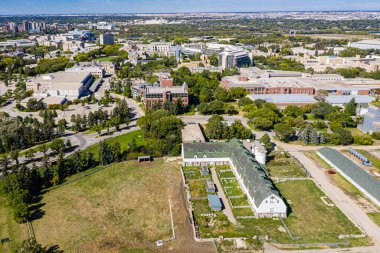 Saskatchewan Üniversitesi 'nin üzerinde süzülen bu dron görüntüsü kampüsün mimari ihtişamını ve akmakta olan Güney Saskatchewan Nehri' ni yakalayarak eğitim ve yenilik mirasını çerçevelemektedir..