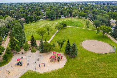 Saskatoon 'daki Adelaide Parkı: sakin bir dinlenme yeri. Bu resim yemyeşil, huzurlu yürüyüş yollarını ve neşeli oyun alanlarını yakalar. Böylece aileler ve doğa severler için mükemmel bir şehir kaçışı olur..