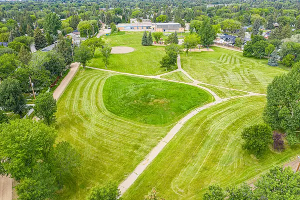 Adelaide Park in Saskatoon: a serene retreat. This image captures its lush greenery, peaceful walking paths, and the joyful play areas, making it a perfect urban escape for families and nature lovers.