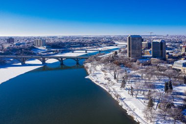 Gökyüzünden Saskatoon 'un kış harikalar diyarına hoş geldiniz. Bu drone görüntüsü karlı şehir manzarasını, donmuş nehir manzarasını ve kışın serin olan kentsel yaşamın dingin güzelliğini yakalar..