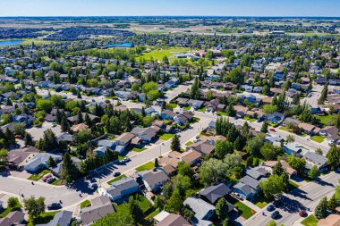 Saskatoon 'daki Lakeridge' in dingin güzelliğini yukarıdan görün. Bu insansız hava aracı görüntüsü mahallelerin sakin caddelerini, yemyeşil alanları ve kentsel ve doğanın ahenkli karışımını gösteriyor..
