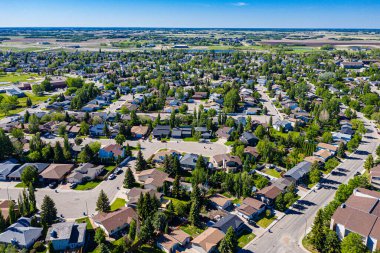 Saskatoon 'daki Lakeridge' in dingin güzelliğini yukarıdan görün. Bu insansız hava aracı görüntüsü mahallelerin sakin caddelerini, yemyeşil alanları ve kentsel ve doğanın ahenkli karışımını gösteriyor..