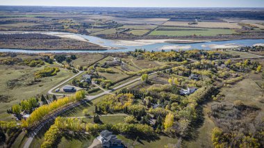 İnsansız hava aracı görüntüsü, büyüleyici sonbahar mevsiminde Riverside Emlak 'ı büyüleyici konutları ve renkli yeşillikleriyle yakalıyor.