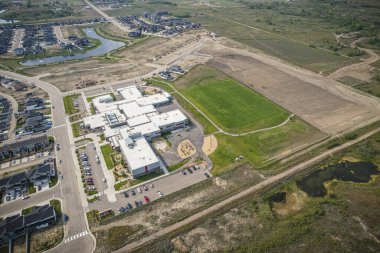 Yaz mevsiminde Saskatchewan 'ın Martensville kentini görüntüleyen İHA görüntüsü, yemyeşil bölgeleriyle çevrili banliyö ve yerleşim alanlarını vurguluyor.