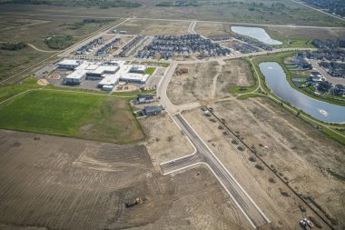 Yaz mevsiminde Saskatchewan 'ın Martensville kentini görüntüleyen İHA görüntüsü, yemyeşil bölgeleriyle çevrili banliyö ve yerleşim alanlarını vurguluyor.