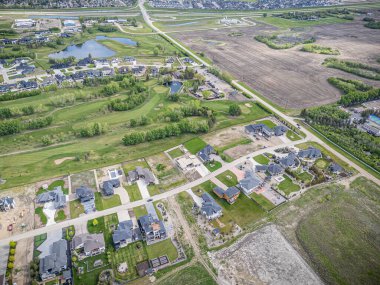 Saskatchewan, Saskatchewan 'daki Greenbryre' in yüksek çözünürlüklü hava aracı fotoğrafı lüks evler, yeşil alanlar, bir golf sahası ve bu lüks yerleşim yerindeki dolambaçlı sokaklar sergileniyor..