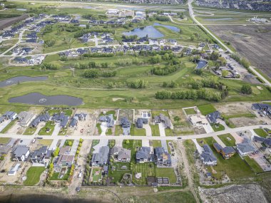 Saskatchewan, Saskatchewan 'daki Greenbryre' in yüksek çözünürlüklü hava aracı fotoğrafı lüks evler, yeşil alanlar, bir golf sahası ve bu lüks yerleşim yerindeki dolambaçlı sokaklar sergileniyor..