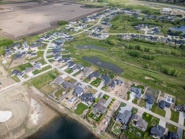 Saskatchewan, Saskatchewan 'daki Greenbryre' in yüksek çözünürlüklü hava aracı fotoğrafı lüks evler, yeşil alanlar, bir golf sahası ve bu lüks yerleşim yerindeki dolambaçlı sokaklar sergileniyor..