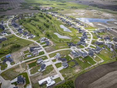Saskatchewan, Saskatchewan 'daki Greenbryre' in yüksek çözünürlüklü hava aracı fotoğrafı lüks evler, yeşil alanlar, bir golf sahası ve bu lüks yerleşim yerindeki dolambaçlı sokaklar sergileniyor..