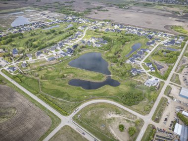 Saskatchewan, Saskatchewan 'daki Greenbryre' in yüksek çözünürlüklü hava aracı fotoğrafı lüks evler, yeşil alanlar, bir golf sahası ve bu lüks yerleşim yerindeki dolambaçlı sokaklar sergileniyor..