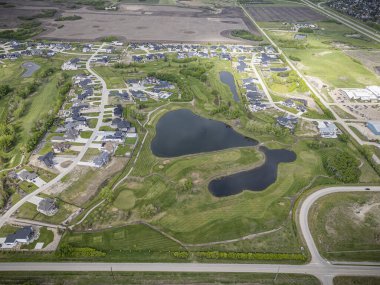 Saskatchewan, Saskatchewan 'daki Greenbryre' in yüksek çözünürlüklü hava aracı fotoğrafı lüks evler, yeşil alanlar, bir golf sahası ve bu lüks yerleşim yerindeki dolambaçlı sokaklar sergileniyor..