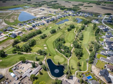 Saskatchewan, Saskatchewan 'daki Greenbryre' in yüksek çözünürlüklü hava aracı fotoğrafı lüks evler, yeşil alanlar, bir golf sahası ve bu lüks yerleşim yerindeki dolambaçlı sokaklar sergileniyor..