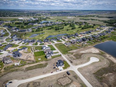 Saskatchewan, Saskatchewan 'daki Greenbryre' in yüksek çözünürlüklü hava aracı fotoğrafı lüks evler, yeşil alanlar, bir golf sahası ve bu lüks yerleşim yerindeki dolambaçlı sokaklar sergileniyor..