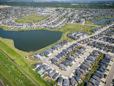 Saskatchewan, Saskatchewan 'daki Stonebridge mahallesinin yüksek çözünürlüklü hava aracı fotoğrafı. Görüntü, yerleşim evleri, ticari alanlar, parklar ve iyi planlanmış caddeleri yakalıyor ve kentsel yaşam ve yeşil alanlar içinde yer alıyor. 