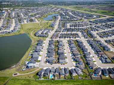 Saskatchewan, Saskatchewan 'daki Stonebridge mahallesinin yüksek çözünürlüklü hava aracı fotoğrafı. Görüntü, yerleşim evleri, ticari alanlar, parklar ve iyi planlanmış caddeleri yakalıyor ve kentsel yaşam ve yeşil alanlar içinde yer alıyor. 