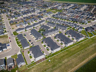 A high-resolution aerial drone photograph of the Stonebridge neighborhood in Saskatoon, Saskatchewan. The image captures residential homes, commercial areas, parks, and well-planned streets, showcasing the mix of urban living and green spaces within  clipart