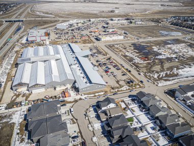 Saskatchewan, Saskatchewan 'daki Brighton banliyö mahallesini gösteren yüksek çözünürlüklü bir hava aracı fotoğrafı. Görüntü, açık bir günde konut, yeşil alanlar, sokaklar ve yakındaki konforların yerleşim yerlerini yakalıyor.