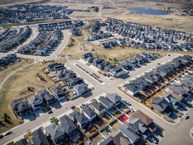 Saskatchewan, Saskatchewan 'daki Brighton banliyö mahallesini gösteren yüksek çözünürlüklü bir hava aracı fotoğrafı. Görüntü, açık bir günde konut, yeşil alanlar, sokaklar ve yakındaki konforların yerleşim yerlerini yakalıyor.