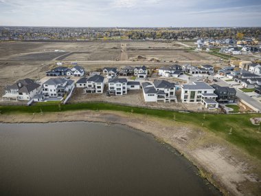 Saskatchewan, Saskatchewan 'daki Brighton banliyö mahallesini gösteren yüksek çözünürlüklü bir hava aracı fotoğrafı. Görüntü, açık bir günde konut, yeşil alanlar, sokaklar ve yakındaki konforların yerleşim yerlerini yakalıyor.