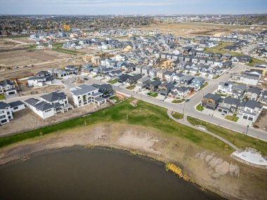 Saskatchewan, Saskatchewan 'daki Brighton banliyö mahallesini gösteren yüksek çözünürlüklü bir hava aracı fotoğrafı. Görüntü, açık bir günde konut, yeşil alanlar, sokaklar ve yakındaki konforların yerleşim yerlerini yakalıyor.
