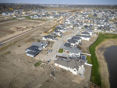 Saskatchewan, Saskatchewan 'daki Brighton banliyö mahallesini gösteren yüksek çözünürlüklü bir hava aracı fotoğrafı. Görüntü, açık bir günde konut, yeşil alanlar, sokaklar ve yakındaki konforların yerleşim yerlerini yakalıyor.