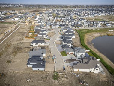 Saskatchewan, Saskatchewan 'daki Brighton banliyö mahallesini gösteren yüksek çözünürlüklü bir hava aracı fotoğrafı. Görüntü, açık bir günde konut, yeşil alanlar, sokaklar ve yakındaki konforların yerleşim yerlerini yakalıyor.