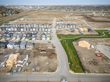 Saskatchewan, Saskatchewan 'daki Brighton banliyö mahallesini gösteren yüksek çözünürlüklü bir hava aracı fotoğrafı. Görüntü, açık bir günde konut, yeşil alanlar, sokaklar ve yakındaki konforların yerleşim yerlerini yakalıyor.