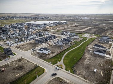 Saskatchewan, Saskatchewan 'daki Brighton banliyö mahallesini gösteren yüksek çözünürlüklü bir hava aracı fotoğrafı. Görüntü, açık bir günde konut, yeşil alanlar, sokaklar ve yakındaki konforların yerleşim yerlerini yakalıyor.