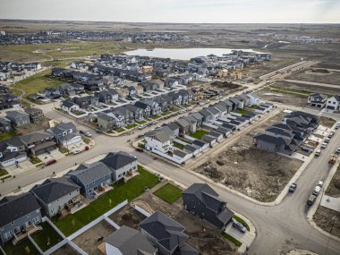 Saskatchewan, Saskatchewan 'daki Brighton banliyö mahallesini gösteren yüksek çözünürlüklü bir hava aracı fotoğrafı. Görüntü, açık bir günde konut, yeşil alanlar, sokaklar ve yakındaki konforların yerleşim yerlerini yakalıyor.
