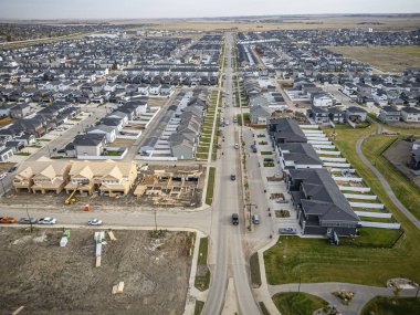 Saskatchewan, Saskatchewan 'daki Brighton banliyö mahallesini gösteren yüksek çözünürlüklü bir hava aracı fotoğrafı. Görüntü, açık bir günde konut, yeşil alanlar, sokaklar ve yakındaki konforların yerleşim yerlerini yakalıyor.