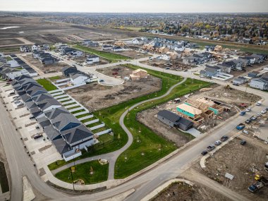 Saskatchewan, Saskatchewan 'daki Brighton banliyö mahallesini gösteren yüksek çözünürlüklü bir hava aracı fotoğrafı. Görüntü, açık bir günde konut, yeşil alanlar, sokaklar ve yakındaki konforların yerleşim yerlerini yakalıyor.