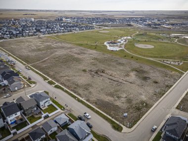 Saskatchewan, Saskatchewan 'daki Brighton banliyö mahallesini gösteren yüksek çözünürlüklü bir hava aracı fotoğrafı. Görüntü, açık bir günde konut, yeşil alanlar, sokaklar ve yakındaki konforların yerleşim yerlerini yakalıyor.