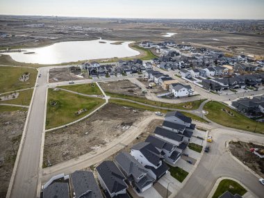 Saskatchewan, Saskatchewan 'daki Brighton banliyö mahallesini gösteren yüksek çözünürlüklü bir hava aracı fotoğrafı. Görüntü, açık bir günde konut, yeşil alanlar, sokaklar ve yakındaki konforların yerleşim yerlerini yakalıyor.