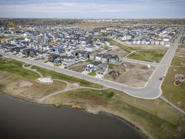 Saskatchewan, Saskatchewan 'daki Brighton banliyö mahallesini gösteren yüksek çözünürlüklü bir hava aracı fotoğrafı. Görüntü, açık bir günde konut, yeşil alanlar, sokaklar ve yakındaki konforların yerleşim yerlerini yakalıyor.