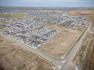 Saskatchewan, Saskatchewan 'daki Brighton banliyö mahallesini gösteren yüksek çözünürlüklü bir hava aracı fotoğrafı. Görüntü, açık bir günde konut, yeşil alanlar, sokaklar ve yakındaki konforların yerleşim yerlerini yakalıyor.