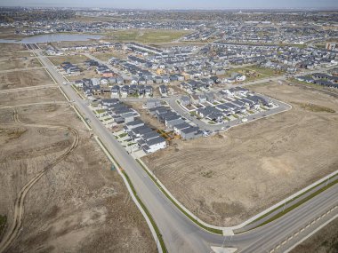Saskatchewan, Saskatchewan 'daki Brighton banliyö mahallesini gösteren yüksek çözünürlüklü bir hava aracı fotoğrafı. Görüntü, açık bir günde konut, yeşil alanlar, sokaklar ve yakındaki konforların yerleşim yerlerini yakalıyor.
