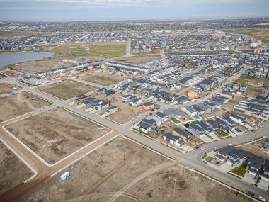 Saskatchewan, Saskatchewan 'daki Brighton banliyö mahallesini gösteren yüksek çözünürlüklü bir hava aracı fotoğrafı. Görüntü, açık bir günde konut, yeşil alanlar, sokaklar ve yakındaki konforların yerleşim yerlerini yakalıyor.