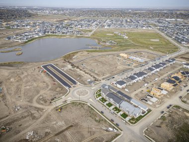 Saskatchewan, Saskatchewan 'daki Brighton banliyö mahallesini gösteren yüksek çözünürlüklü bir hava aracı fotoğrafı. Görüntü, açık bir günde konut, yeşil alanlar, sokaklar ve yakındaki konforların yerleşim yerlerini yakalıyor.