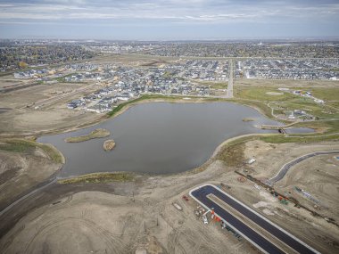 Saskatchewan, Saskatchewan 'daki Brighton banliyö mahallesini gösteren yüksek çözünürlüklü bir hava aracı fotoğrafı. Görüntü, açık bir günde konut, yeşil alanlar, sokaklar ve yakındaki konforların yerleşim yerlerini yakalıyor.