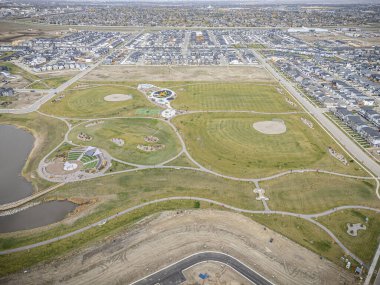 Saskatchewan, Saskatchewan 'daki Brighton banliyö mahallesini gösteren yüksek çözünürlüklü bir hava aracı fotoğrafı. Görüntü, açık bir günde konut, yeşil alanlar, sokaklar ve yakındaki konforların yerleşim yerlerini yakalıyor.