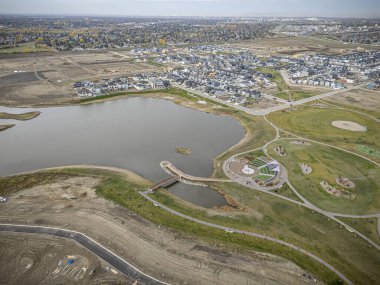 Saskatchewan, Saskatchewan 'daki Brighton banliyö mahallesini gösteren yüksek çözünürlüklü bir hava aracı fotoğrafı. Görüntü, açık bir günde konut, yeşil alanlar, sokaklar ve yakındaki konforların yerleşim yerlerini yakalıyor.