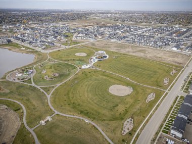 Saskatchewan, Saskatchewan 'daki Brighton banliyö mahallesini gösteren yüksek çözünürlüklü bir hava aracı fotoğrafı. Görüntü, açık bir günde konut, yeşil alanlar, sokaklar ve yakındaki konforların yerleşim yerlerini yakalıyor.